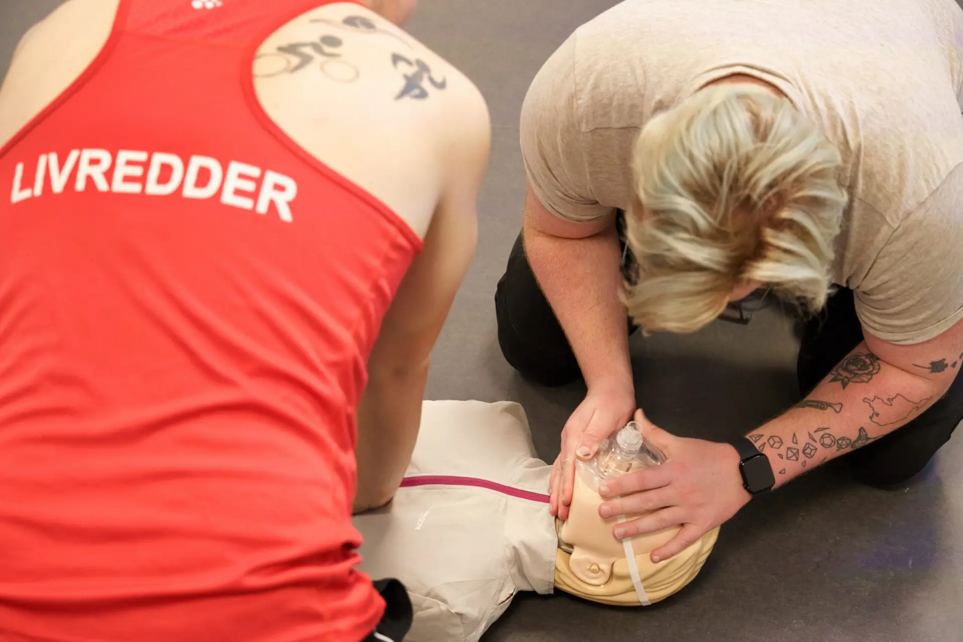 Hjerte-lunge-redning med kompressioner og indblæsninger Livreddere udfører hjerte-lunge-redning med kompressioner og indblæsninger igennem en pocketmask.